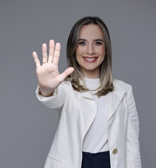 Dra. Rafaela Pagliosa Winter acenando, convite para tirar dúvidas sobre implante pelo WhatsApp