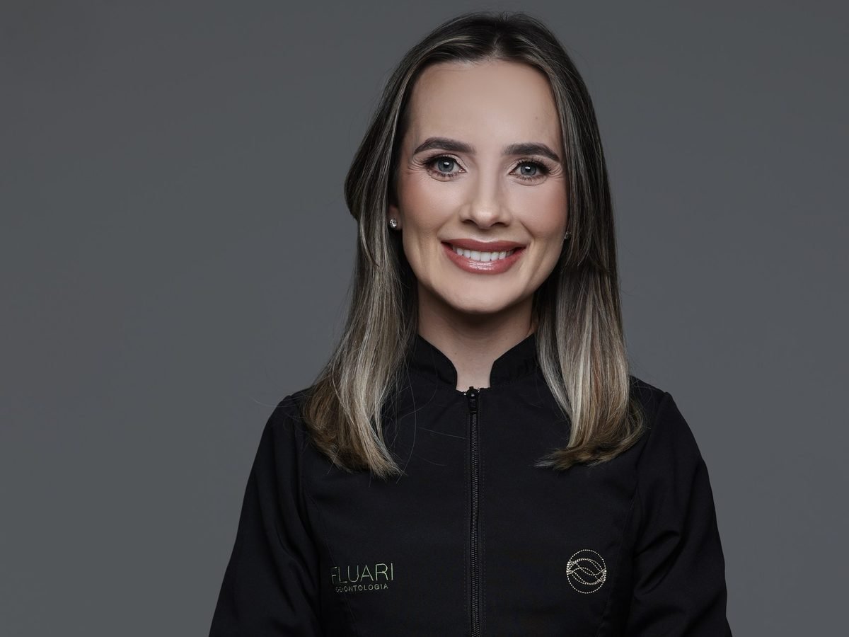 Dra. Rafaela Pagliosa Winter de jaleco da Fluari Odontologia, de braços cruzados