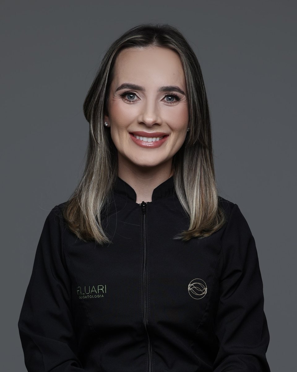 Dra. Rafaela Pagliosa Winter, cirurgiã-dentista que faz tratamento de canal na Fluari Odontologia em Lages/SC, de jaleco da clínica